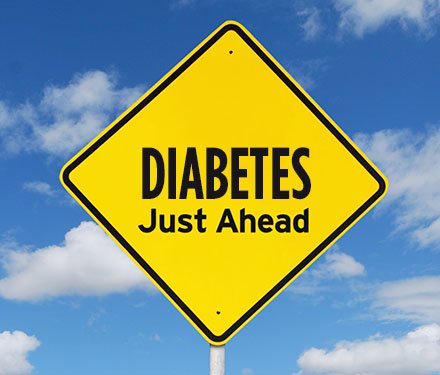 A yellow warning street sign with the words "Diabetes just ahead" on it