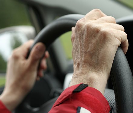 Close up of hands on a steering wheel